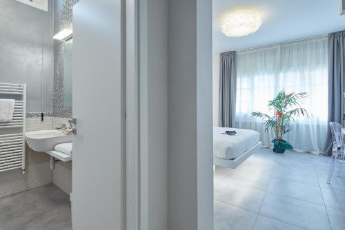 a white bathroom with a bed and a sink at Via Roma 25 Bed&Breakfast in Arezzo