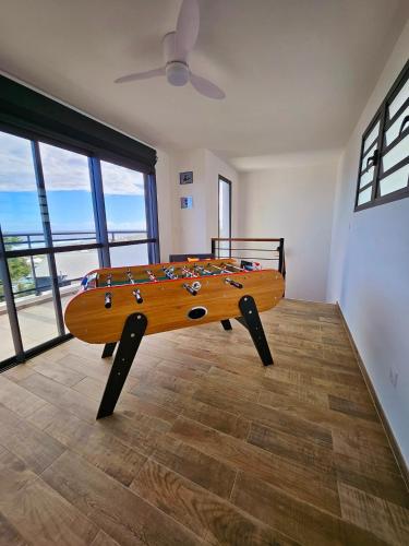a wooden table in a room with a surfboard on it at L'Anse des Baleines, Vue panoramique sur l'océan, Piscine & Confort 4 étoiles in Petite Île
