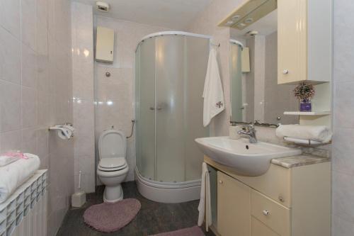 ein Badezimmer mit Dusche, Toilette und Waschbecken in der Unterkunft Holiday home Lucy with private pool in Kaštela