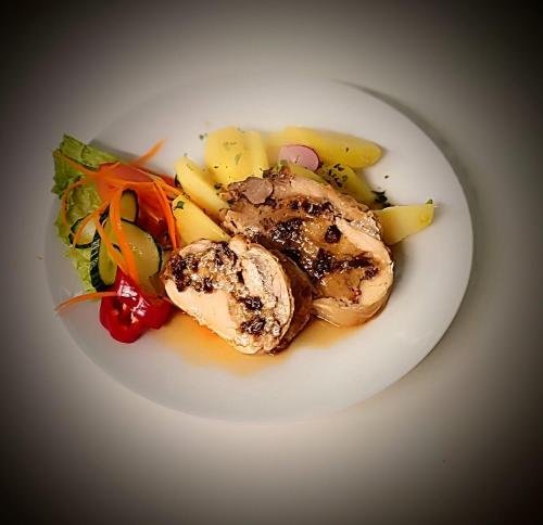 a white plate of food with meat and vegetables at Pension Helene s mini pivovarem in Kytlice