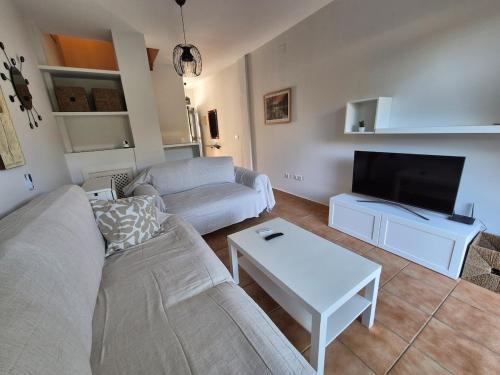 イスランティージャにあるCasa adosada en el campo de golf de Islantillaのソファとテレビのあるリビングルーム