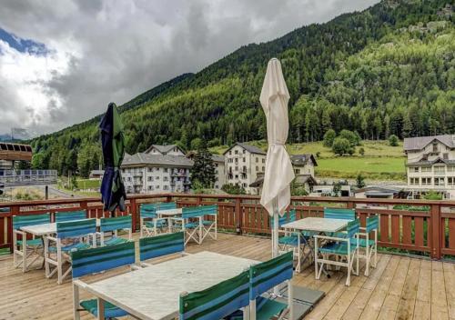 a deck with tables and chairs and a mountain at Charming Apartment Chamonix Valley in Vallorcine