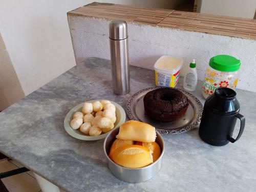 a table topped with plates of food and a cake at Casinha da Alê in Mongaguá