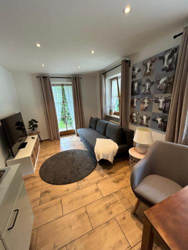 een woonkamer met een bank en een tafel bij Fewo Auszeit am Königssee in Schönau am Königssee