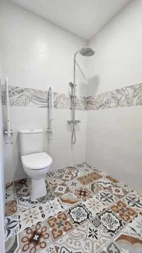 a bathroom with a toilet and a tile floor at Hotel Tuul Etxea in Galdakao