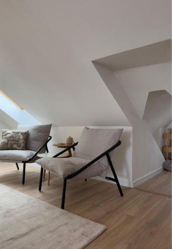 a living room with a chair and a table at ApartNaest Radeberg - vollausgestattete 1 - 4 Zimmer Apartments I 24h flexibler mobiler Check-in via Link I Parkplatz auf Anfrage I Platz für bis zu 60 Personen in Radeberg