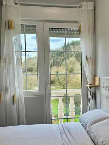 a bedroom with two beds and a large window at La Casa de Praves in Praves