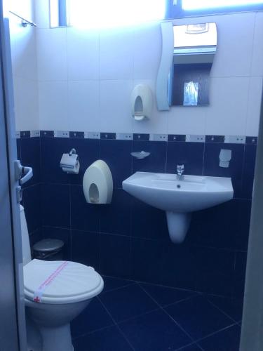 a blue bathroom with a toilet and a sink at Afrodita Hotel in Sinemorets