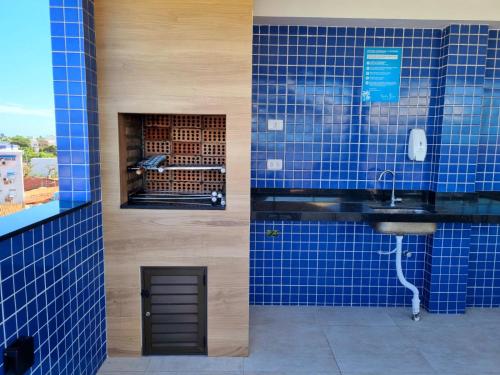a bathroom with blue tiled walls and a sink at Porto BLUE 05 térreo Centro de Porto de Galinhas in Porto De Galinhas