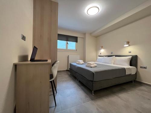 a bedroom with a bed and a desk with a laptop at Leonidio Apartment Zenith-Nadir in Leonidion
