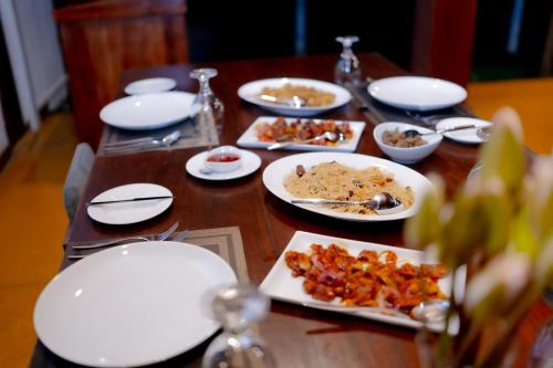 a wooden table with plates of food on it at Tribe Wilpattu - Eco Lodge in Wilpattu