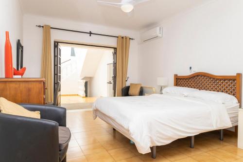a bedroom with a large white bed and chairs at Vila Van Gogh in Luz