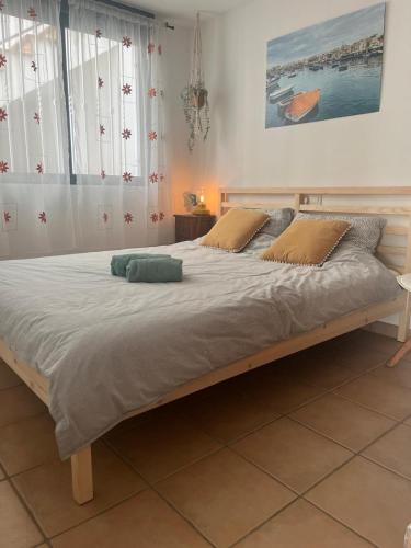 a large bed in a bedroom with white walls and windows at Vista al mar Peñiscola in Peniscola