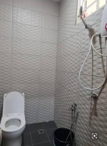 a bathroom with a white toilet in a room at CBHResort Agrofarm in Baling