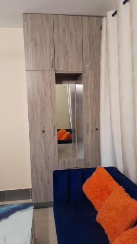 a blue couch in a room with a mirror at MJ homes in Mtwapa