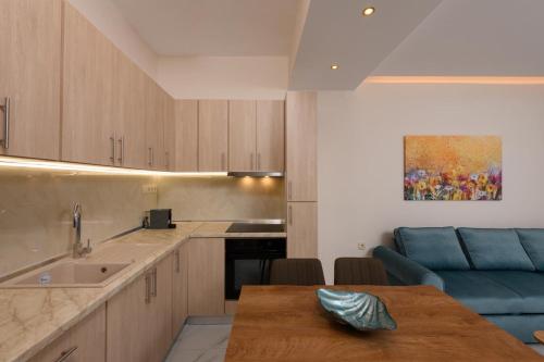 a kitchen with a table and a blue couch at Ninemia House in Limenas
