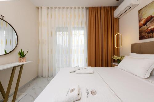 a bedroom with a large white bed and a window at Ninemia House in Limenas