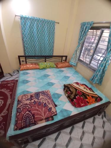 a bed with pillows on it in a room at Ghosh homestay 8 in kolkata