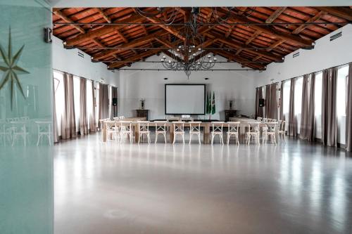 a large room with tables and a screen in it at Borgo Pallavicini Mori in Prima Porta