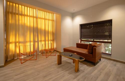 a living room with a couch and two chairs at Quad Club - Resort and Spa, Nandi Hills in Nandigunda