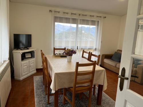 a dining room with a table with chairs and a television at Casa de Casarelhos - Vistas rio - "Gerês" in Geres