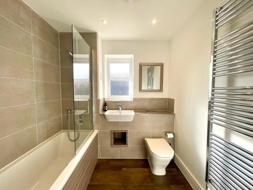 a bathroom with a toilet and a sink and a shower at New Modern 2 Bed with parking in BISHOPS STORTFORD, close to Stansted Airport! in Bishops Stortford