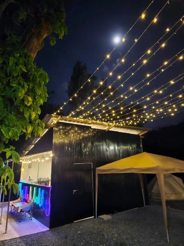 a tent with lights on top of a building at Nahm Khao Sok Hostel and Camping in Khao Sok