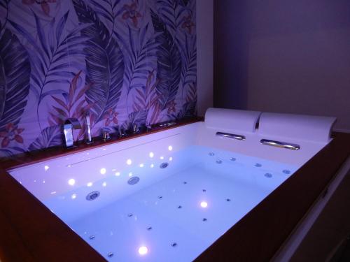 y baño con bañera y cortina de ducha púrpura. en Tropical Relax Suite, en Ponte Lucano