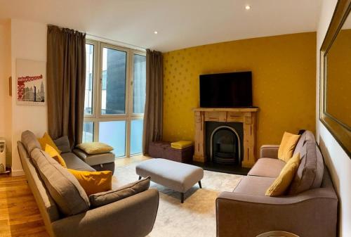 a living room with two couches and a fireplace at Oswald Apartment - Glasgow City Centre in Glasgow