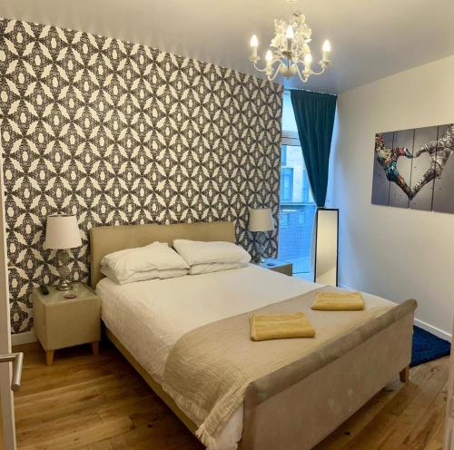 a bedroom with a large bed and a chandelier at Oswald Apartment - Glasgow City Centre in Glasgow