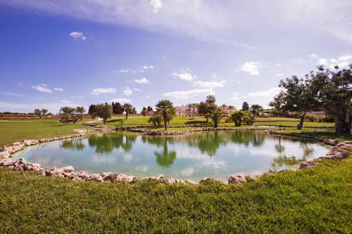 a pond in the middle of a field at Relais Masseria Caselli in Carovigno