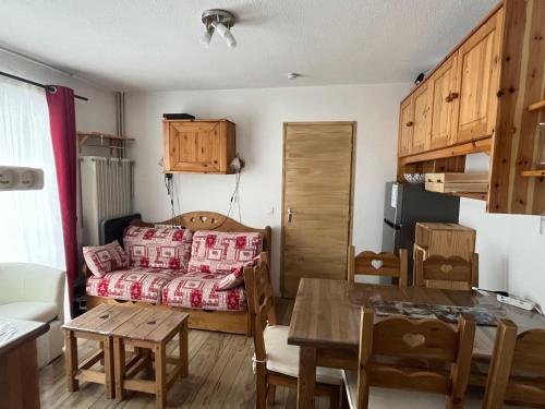 une petite pièce avec un lit et une table dans l'établissement Le JETAY 39 App 6 personnes aux MENUIRES, aux Menuires