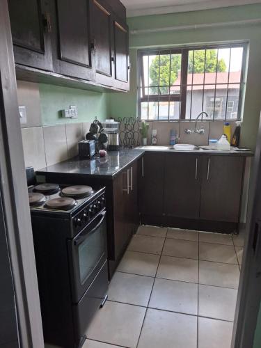 a small kitchen with a stove and a sink at Theza's Place in Johannesburg