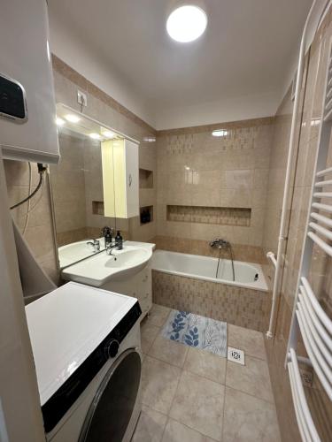 a bathroom with a tub and a sink and a bath tub at Bende-lak in Nyíregyháza