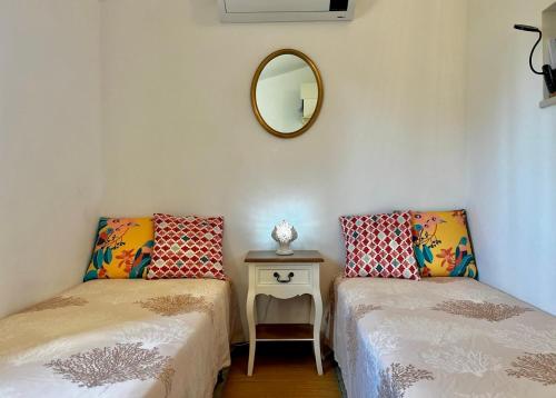 a room with two beds and a mirror on the wall at Villa Colle dei Trulli Monopoli in Monopoli