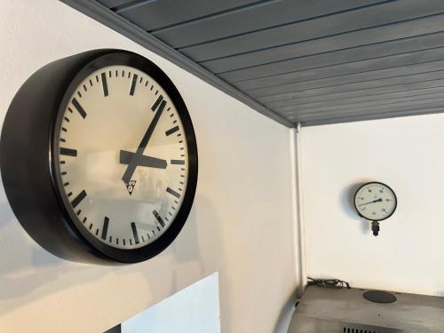 a black clock on the wall next to two clocks at Penzio Ostrava in Ostrava