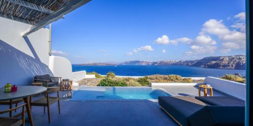 a villa with a pool and a view of the ocean at Neptune Luxury Suites in Akrotiri