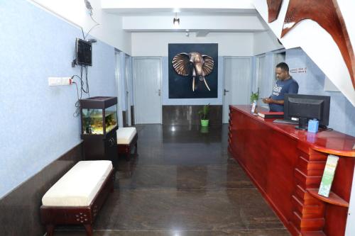 a man sitting at a reception desk in a room at Sauhrudam Resort and Restaurant-Kanyakumari in Kanyakumari