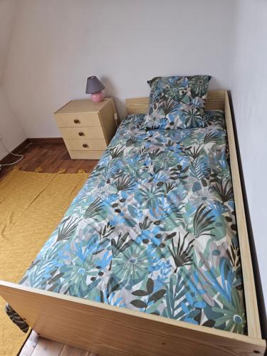 une chambre avec un lit avec un couvre-lit à fleurs bleu dans l'établissement Maison ancienne, à Plougasnou