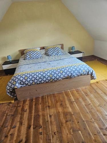 une chambre avec un lit et un parquet dans l'établissement Maison ancienne, à Plougasnou