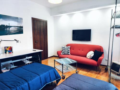 サレルノにあるSalerno Place - Design Houseの赤いソファとベッドのあるリビングルーム