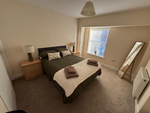 a bedroom with a bed with towels on it at New cosy ground floor flat in Hawick