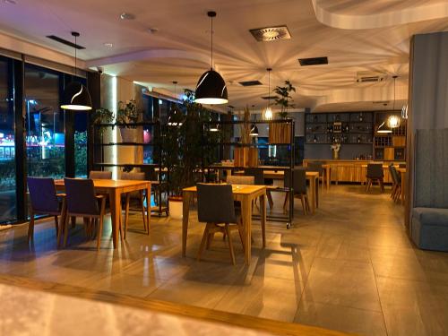 a restaurant with tables and chairs in a room at Hotel GOLD JET Bihać in Bihać