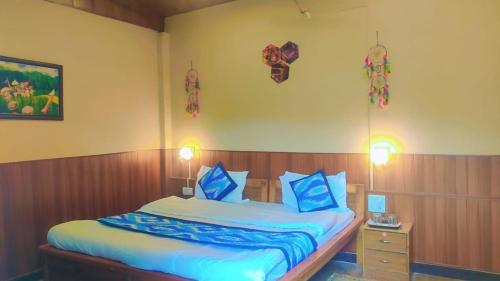 a bedroom with a bed with blue and white sheets at The Lake & woods in Bhīm Tāl