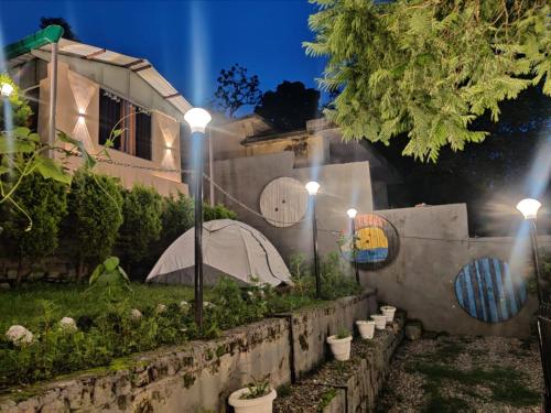 a garden with lights on the side of a house at The Lake & woods in Bhīm Tāl