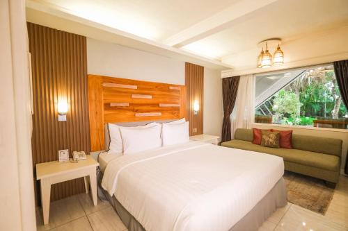 a bedroom with a large bed and a couch at Peneeda View Beach Hotel in Sanur