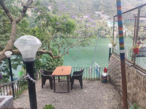 a table and chairs with a view of the water at The Lake & woods in Bhīm Tāl