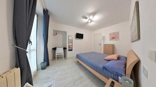 a bedroom with a bed and a desk in a room at Il Gatto e La Volpe Foresteria Lombarda in Lierna