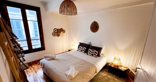 a bedroom with a bed and two windows at Hypercenter - Wifi - In the heart of Avignon! in Avignon