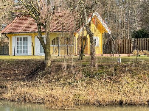 a yellow house with a tree in front of it at Haus Miriam in Walchum